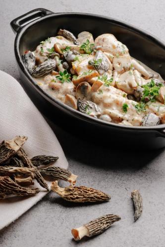 a pan of food with chicken and mushrooms on a table at CHAO Sanlitun Beijing in Beijing