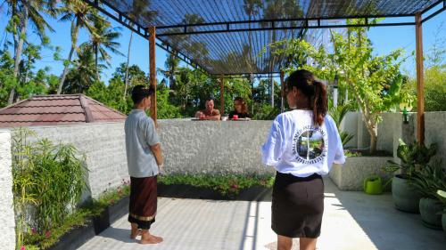 a man and a woman standing in front of a fence at BALI AMED FEEL HOME VILLA in Amed