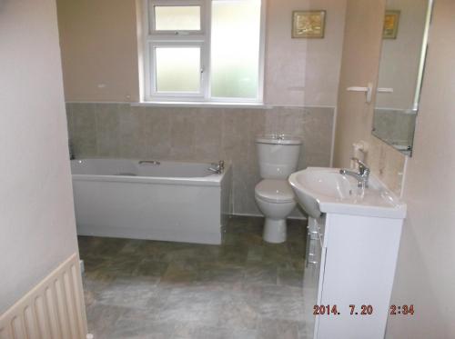 a bathroom with a tub and a toilet and a sink at Rose Cottage in Kilcrohane