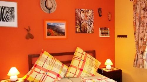 a bedroom with orange walls and a bed with pillows at Can Laika in Cala Pi