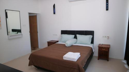 a bedroom with a large bed with two night stands at BALI AMED FEEL HOME VILLA in Amed