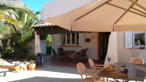 a patio with a table and a large umbrella at Can Laika in Cala Pi
