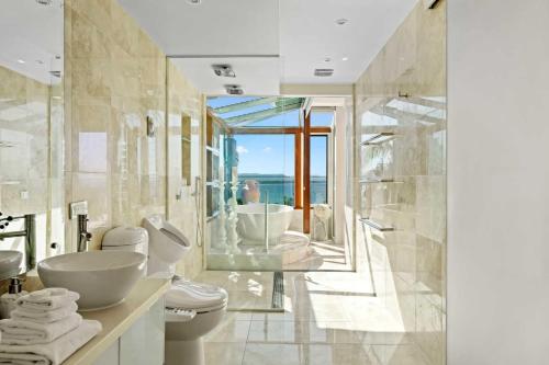 a bathroom with a sink toilet and a shower at Villa Gabrielle in Byron Bay