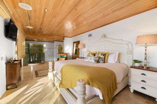 a bedroom with a large bed and a wooden ceiling at Villa Gabrielle in Byron Bay
