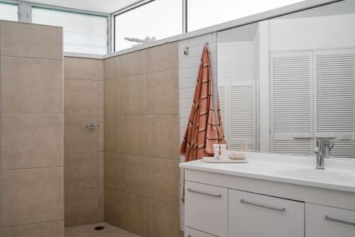 a bathroom with a shower and a sink and a shower at Baywatch at Wategos in Byron Bay