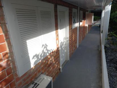 a hallway of a brick building with a window at Casa Brasil pousada e lazer in Trindade
