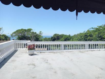 a vase of flowers sitting on a white bridge at Casa Brasil pousada e lazer in Trindade