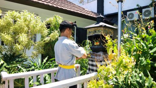 a man standing on a fence in front of a shrine at BALI AMED FEEL HOME VILLA in Amed