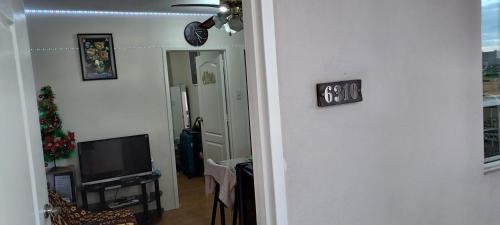 a hallway with a living room with a television at Two-Bedroom at San Remo Oasis in Cebu City