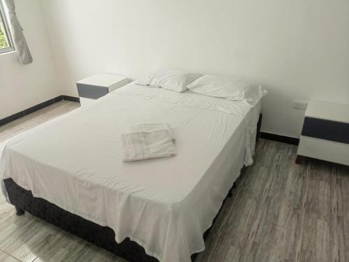 a white bed with a white towel on it at Villa Aurora in Ricaurte