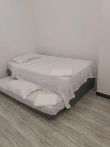 a bed with white sheets and pillows in a room at Villa Aurora in Ricaurte