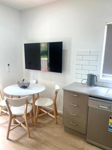 a kitchen with a white table and chairs and a table and a sink at Bundalong Villas in Bundalong