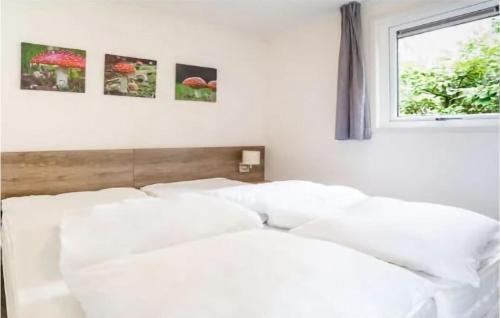 Cette chambre comprend un lit avec des oreillers blancs et une fenêtre. dans l'établissement 2 Bedroom Stunning stacaravan In Vorden, à Vorden