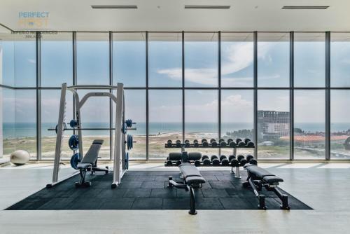 een fitnessruimte met uitzicht op de oceaan bij Imperio Residence Seafront by Perfect Host in Melaka