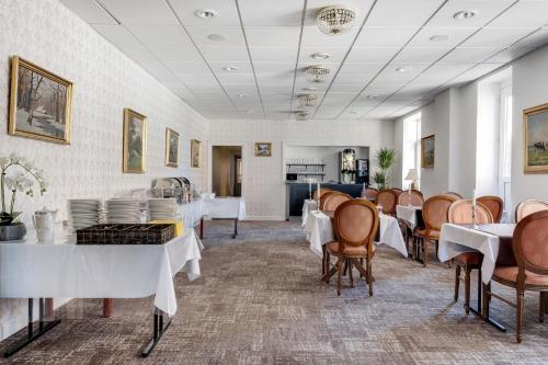 ein Esszimmer mit weißen Tischen und Stühlen in der Unterkunft Hotel Postgaarden in Fredericia