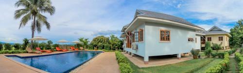 a villa with a swimming pool and a house at Baan innto resort in Fang