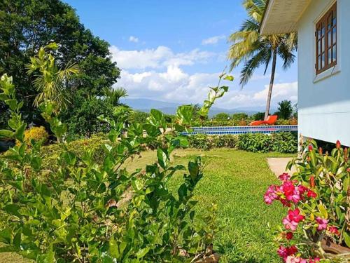 a yard with flowers and a house and a palm tree at Baan innto resort in Fang