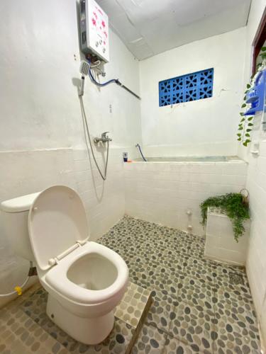 a bathroom with a toilet and a shower at Neo Robiu & Ijen Tour in Banyuwangi