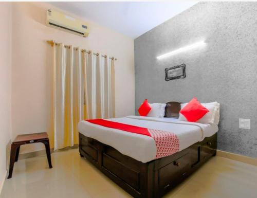 a bedroom with a large bed with red pillows at JK BNB Stay in Vagator
