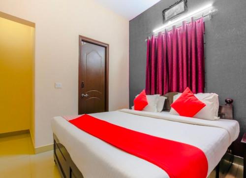 1 dormitorio con 1 cama grande con almohadas rojas en JK BNB Stay, en Vagator