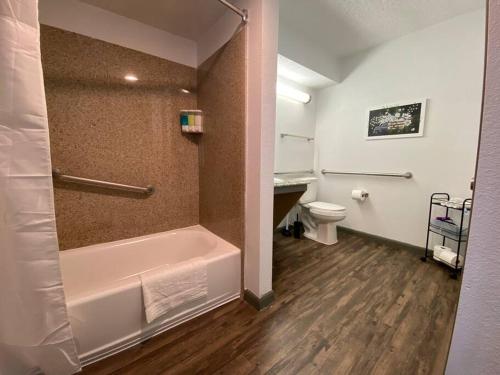 a bathroom with a bath tub and a toilet at Magnolia Suiteking Bednrgmed Center1st Floor in Houston