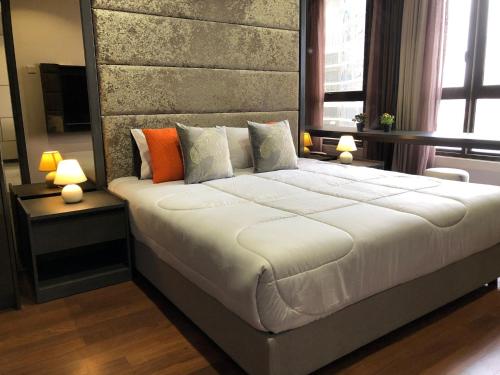 8 Kia Peng Residences by StayHere في كوالالمبور: غرفة نوم بسرير كبير ومصباحين