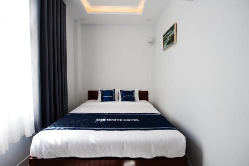 a bedroom with a bed with blue pillows on it at The White House in Ho Chi Minh City