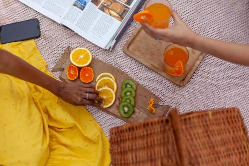 a woman sitting on the floor with fruits and vegetables at StayVista's Shivom Villa 12 - A Serene Escape with Views of the Valley and Lake in Lonavala