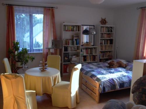 1 dormitorio con 1 cama, mesa y sillas en Gästezimmer Ferienwohnung VILLA ALEXA, mit Wallbox, en Woltersdorf