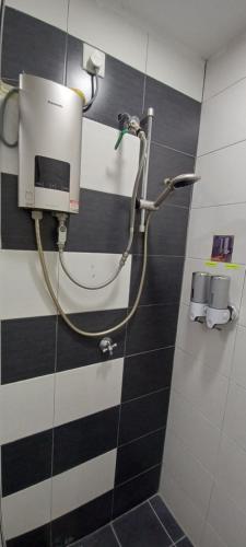 a shower in a bathroom with black and white tiles at SY Staycation - Studio in Bayan Lepas