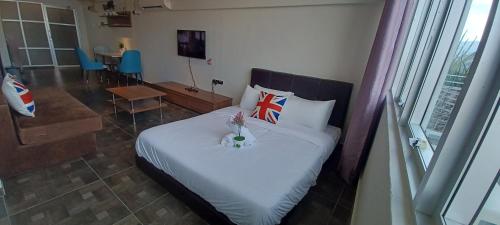 a bedroom with a bed with a flag pillow on it at SY Staycation - Studio with Netflix in Bayan Lepas