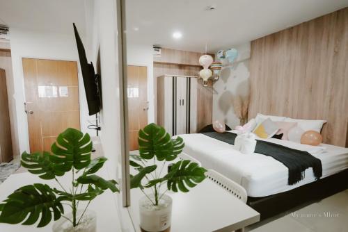 ein Schlafzimmer mit einem Bett mit weißer Bettwäsche und Pflanzen in der Unterkunft 88 Living in Bangkok