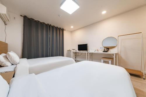 a hotel room with two beds and a mirror at Seorak HOT Spring Mammoth Resotel in Sokcho