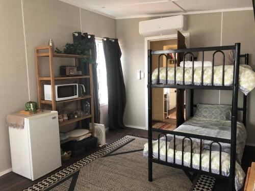 a room with two bunk beds and a microwave at Corella Creek Country Farm Stay in Nelia