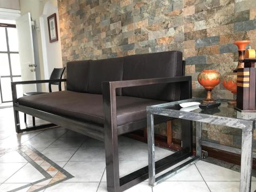 a black couch in a room with a table at Vacaciones Playa Club Casa Blanca Same Esmeraldas in Same