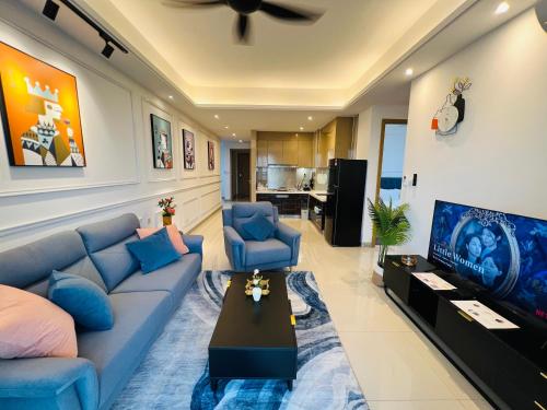 a living room with a blue couch and a tv at R&F PRINCESS COVE at ANJU in Johor Bahru