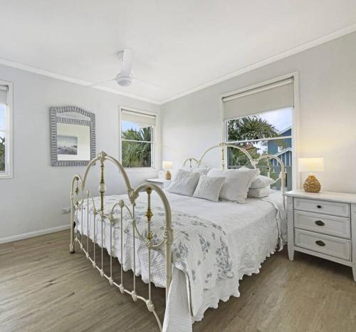 a white bedroom with a white bed and a window at Studio Seaside Self-contained apartment in Marcoola