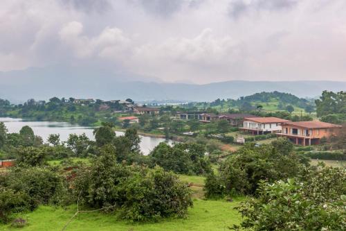 Blick auf ein Dorf mit einem Fluss und Häusern in der Unterkunft StayVista's Shivom Villa 1 - A Serene Escape with Views of the Valley and Lake in Lonavla
