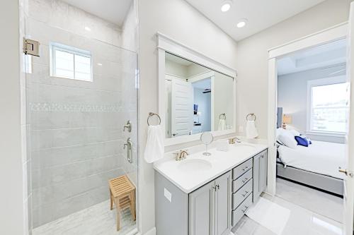 a white bathroom with a shower and a sink and a mirror at Prominence Moby Dick in Inlet Beach