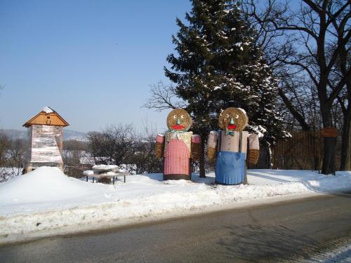 a group of three statues in the snow next to a tree at Apartments Akacijev Izvir in Miklavž na Dravskem Polju