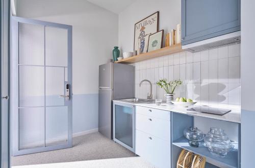 a kitchen with a sink and a refrigerator at M Village Living Lý Chính Thắng in Ho Chi Minh City