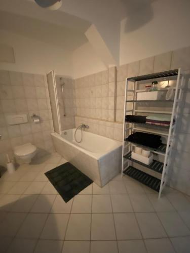 ein weißes Bad mit einer Badewanne und einem WC in der Unterkunft Bezauberndes Stadtidyll in Lichtenstein
