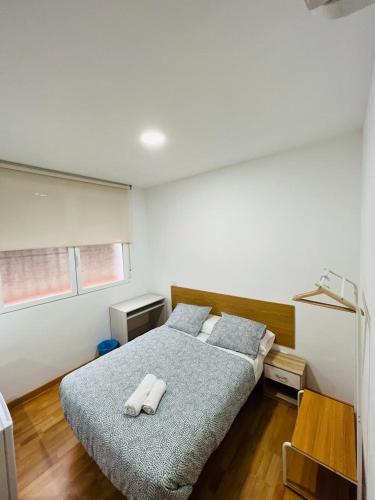 1 dormitorio con 1 cama y 2 toallas blancas en HOSPEDAJE COLONIA VALLECAS, en Madrid