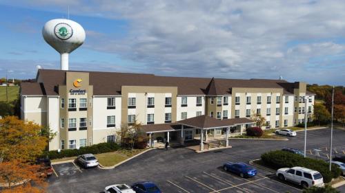 a hotel with a water tower in front of a parking lot at Comfort Inn & Suites Geneva- West Chicago in Geneva