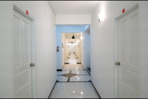 pasillo con puertas blancas y suelo de baldosa en Solo Ace Hotel, en Ernakulam