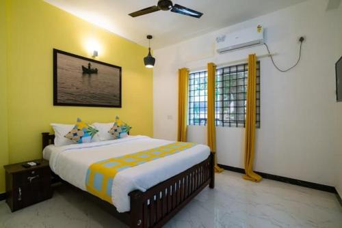 1 dormitorio con 1 cama grande y paredes amarillas en Solo Ace Hotel, en Ernakulam