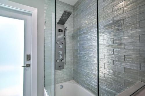 a bathroom with a tub and a glass shower at Modern Wilton Manors Home with Outdoor Oasis! in Fort Lauderdale
