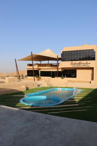 a large swimming pool in front of a building at Sand House ساند هاوس in Al Raka