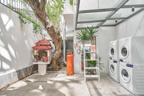ホーチミン・シティにあるM Village Living Tú Xươngの洗濯機と木のあるランドリールーム