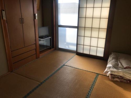 a room with a room with a door and a television at Ryokan Minami - Vacation STAY 01901v in Tsuchiura
